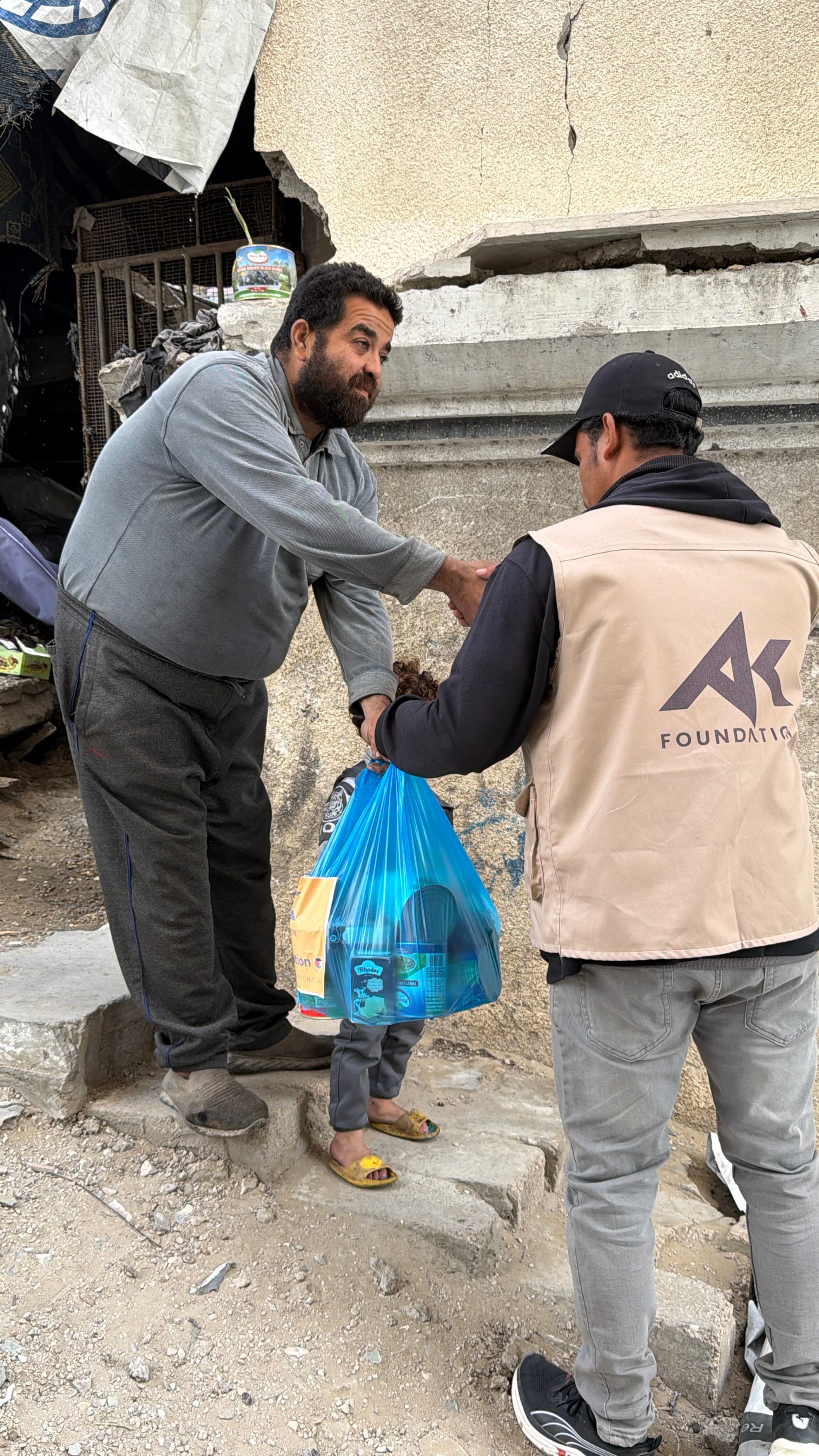 An AKF team member handing supplies to a recipient in Gaza.